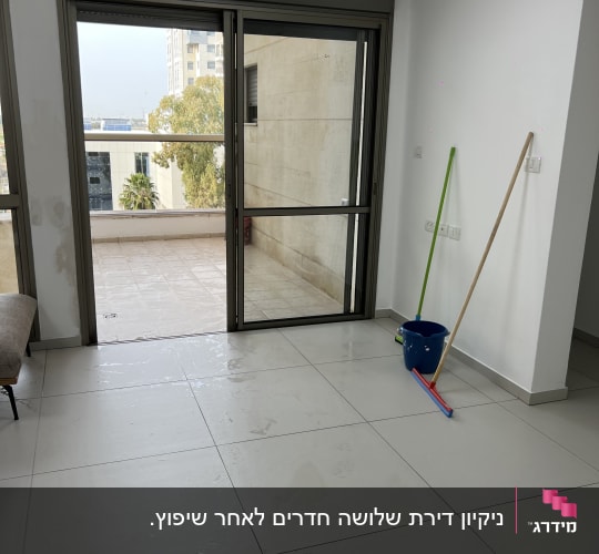 מגב ודלי כחול על רצפה רטובה